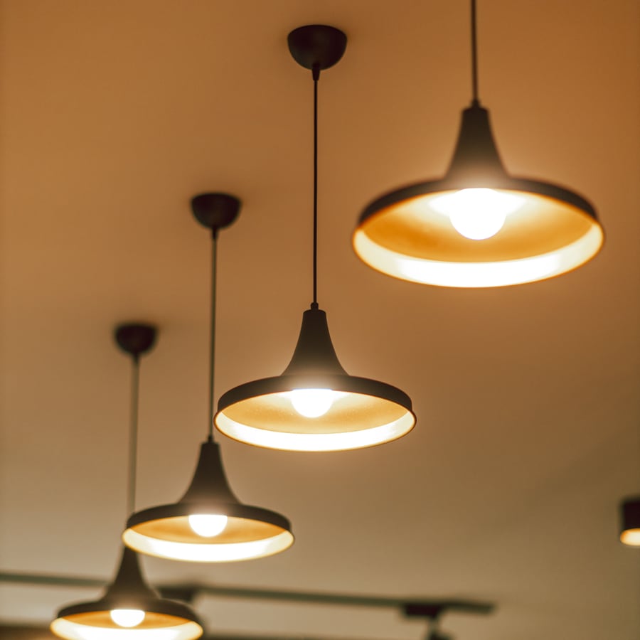 Vom Elektriker montierte Pendelleuchten geben warmes Licht in einem Wohnraum