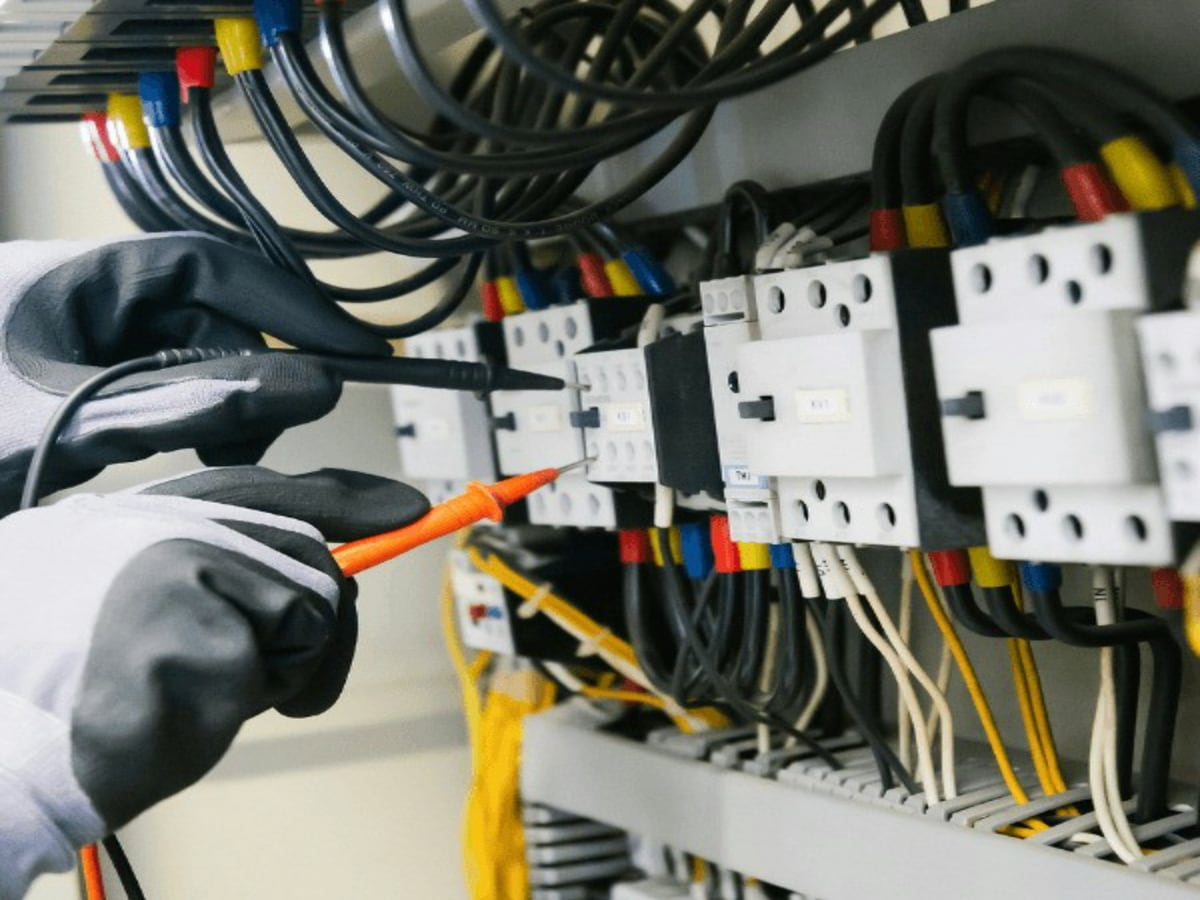 Elektriker prüft mit einem Multimeter Bauteile in einem Zählerschrank