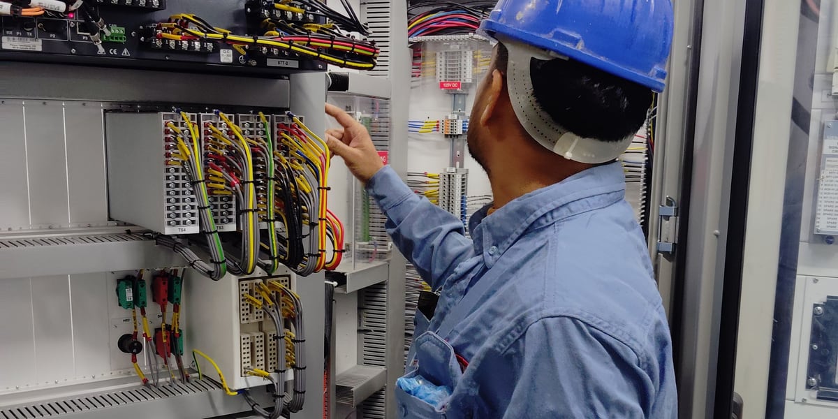 Elektriker bei der Prüfung eines Schaltschranks in einer Gewerbeeinheit